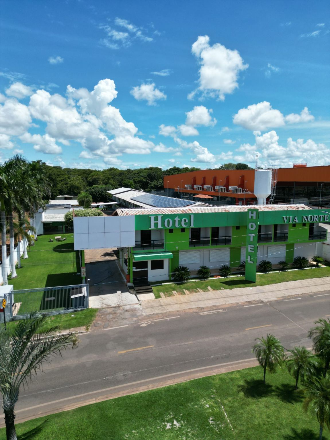 Fachada do Via Norte Hotel com o letreiro verde, vista da rua de acesso pela BR-153